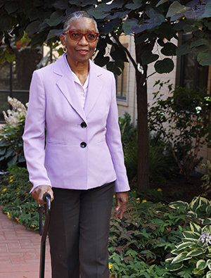 Woman with cane walking outdoors.