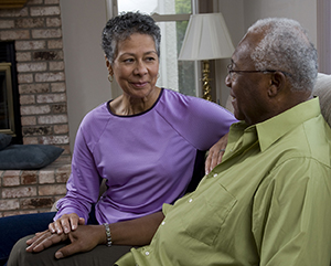 Man and woman sitting on couch, talking.