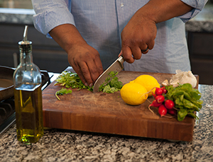 Man chopping fresh vegetables in kitchen.