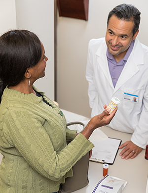 Woman talking to pharmacist at pharmacy counter.