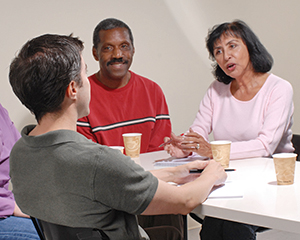 Two men and two women sitting at table, talking.