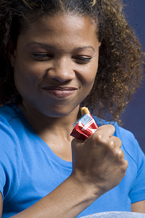 Woman crushing pack of cigarettes.