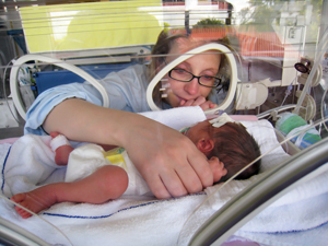 Mujer que mira a un bebé en una incubadora.